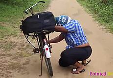 Местно момиче на велосипед получава помощ за поправка в храстите