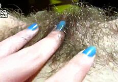 Gros clito d'une chatte poilue collante en gros plan