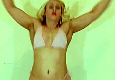 Blond mladá 18+ v mikro bikinách ukazuje svalnaté telo počas intenzívneho kardio workoutu v gyme