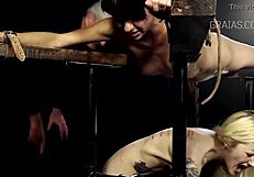 Svázaná holka snáší tvrdé bičování, zatímco jí na kůži kape horký vosk.