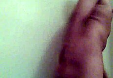 In the dimly lit room, a gay man takes a dildo deep in his ass.