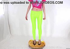 Beautiful legged woman steps on cushion with high heels, showcasing her shoe fetish.