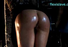 BDSM model Alex Zothberg in bondage getting naked, oiled, and whipped.