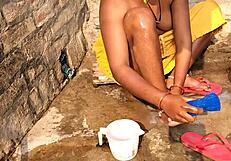 Indian wife Radhika bathes in the summer sun in the yard with her upper body naked