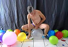 Mature gay DILF Richard Lennox plays with balloons during session