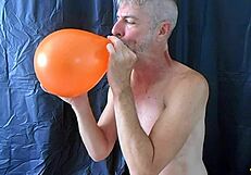 Mature gay DILF Richard Lennox plays with balloons during session