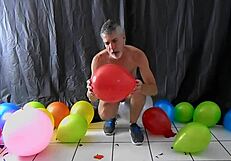 Mature gay DILF Richard Lennox plays with balloons during session