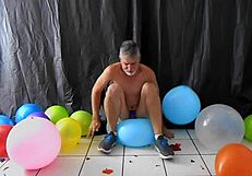 Mature gay DILF Richard Lennox plays with balloons during session