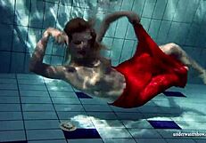 Russian teen Lucie enjoys underwater swimming in the pool.