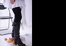 The boot crushes food in a fetish scene, leaving messy remains on the floor.