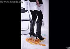 The boot crushes food in a fetish scene, leaving messy remains on the floor.