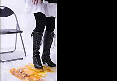 The boot crushes food in a fetish scene, leaving messy remains on the floor.