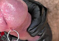 Extreme close-up of latex gloves on peehole with intense cumshot