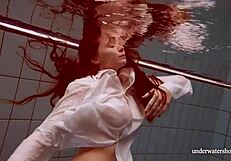 Blonde beauty wearing bikini – attractive woman playing with water in public swimming pool