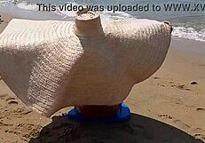 Huge-titted woman flashes her hairy pussy and small tits on a public beach.