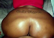 Ebony woman with big oiled ass in black setting