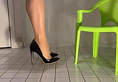 Maid cleans in pvc outfit dangling shoes