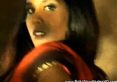 Brunette undresses while dancing in erotic striptease, teasing with ripped clothes.