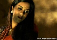 Brunette undresses while dancing in erotic striptease, teasing with ripped clothes.