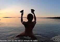 nude fire dancer seduces on beach at sunset