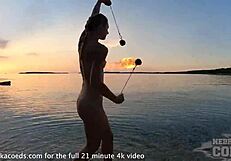 nude fire dancer seduces on beach at sunset