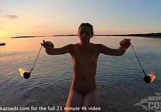 nude fire dancer seduces on beach at sunset