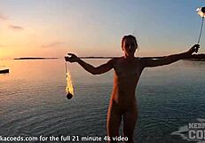 nude fire dancer seduces on beach at sunset