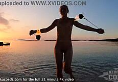 nude fire dancer seduces on beach at sunset