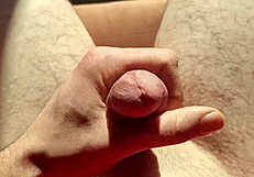 edging flaccid cock with precum in natural light