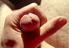 edging flaccid cock with precum in natural light