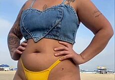 African woman flashes and arouses guy on beach.