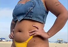 African woman flashes and arouses guy on beach.