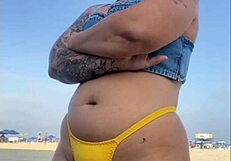 African woman flashes and arouses guy on beach.