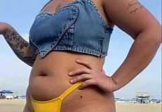 African woman flashes and arouses guy on beach.