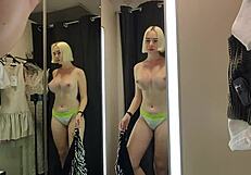 Blonde tries on clothes in mall fitting room