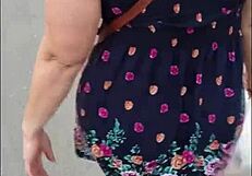 curvy mature woman walks street in skirt