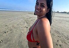On the beach, she fingers her wet pussy under the sun.
