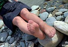 goddess teases with tan nylon soles and toes by the riverside, close-up fetish delight