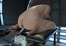 Is that machine banging her shaved pussy?