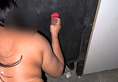 I grind my ass on the black guy's cock and he cums in my hand at the glory hole.