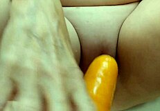 Amateur housewife passionately fucks her pussy with a big fat carrot in homemade video.