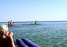 nude blonde beauty exposes big boobs on public beach with dolphin tattoo