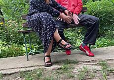 Milf subtly jerks big dick into glass on park bench