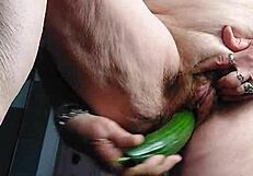 granny teases her hairy old pussy with a thick cucumber insertion