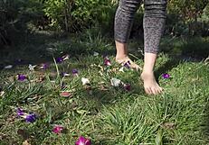 Barefoot toes tease and crush flowers across the grassy ranch