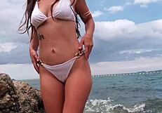 petite babe in tropical bikini teases on beach craving your gaze all over her sexy curves