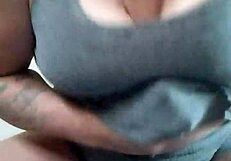 Tattooed brunette slut rams dildo between massive titties hard!