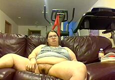 Chubby Fat Woman Pisses Hard While Watching TV Intensely. Urine Streams Soak Couch in Bold Display