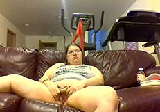 Chubby Fat Woman Pisses Hard While Watching TV Intensely. Urine Streams Soak Couch in Bold Display