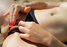 Who spots a girl fingering shaved pussy to wet orgasm on public beach?